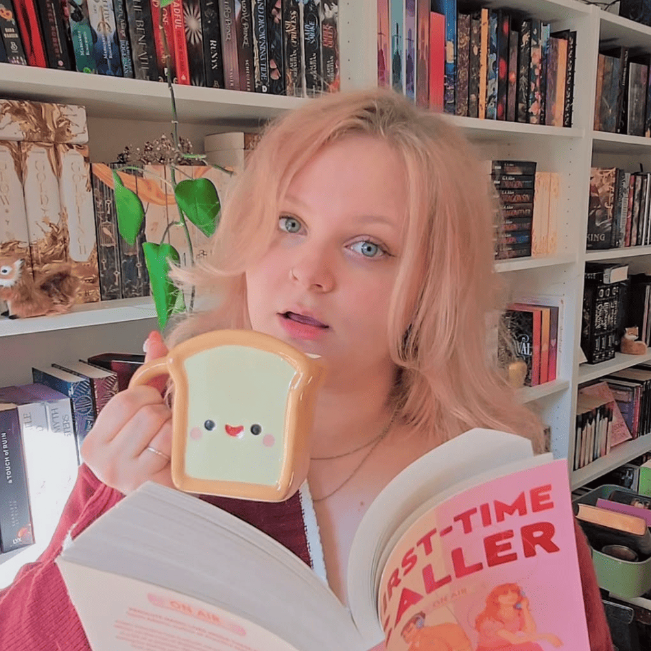 lauri.ollii mit Toast-Tasse und First Time Caller von B.K. Borison in der Hand vor ihrem Bücherregal